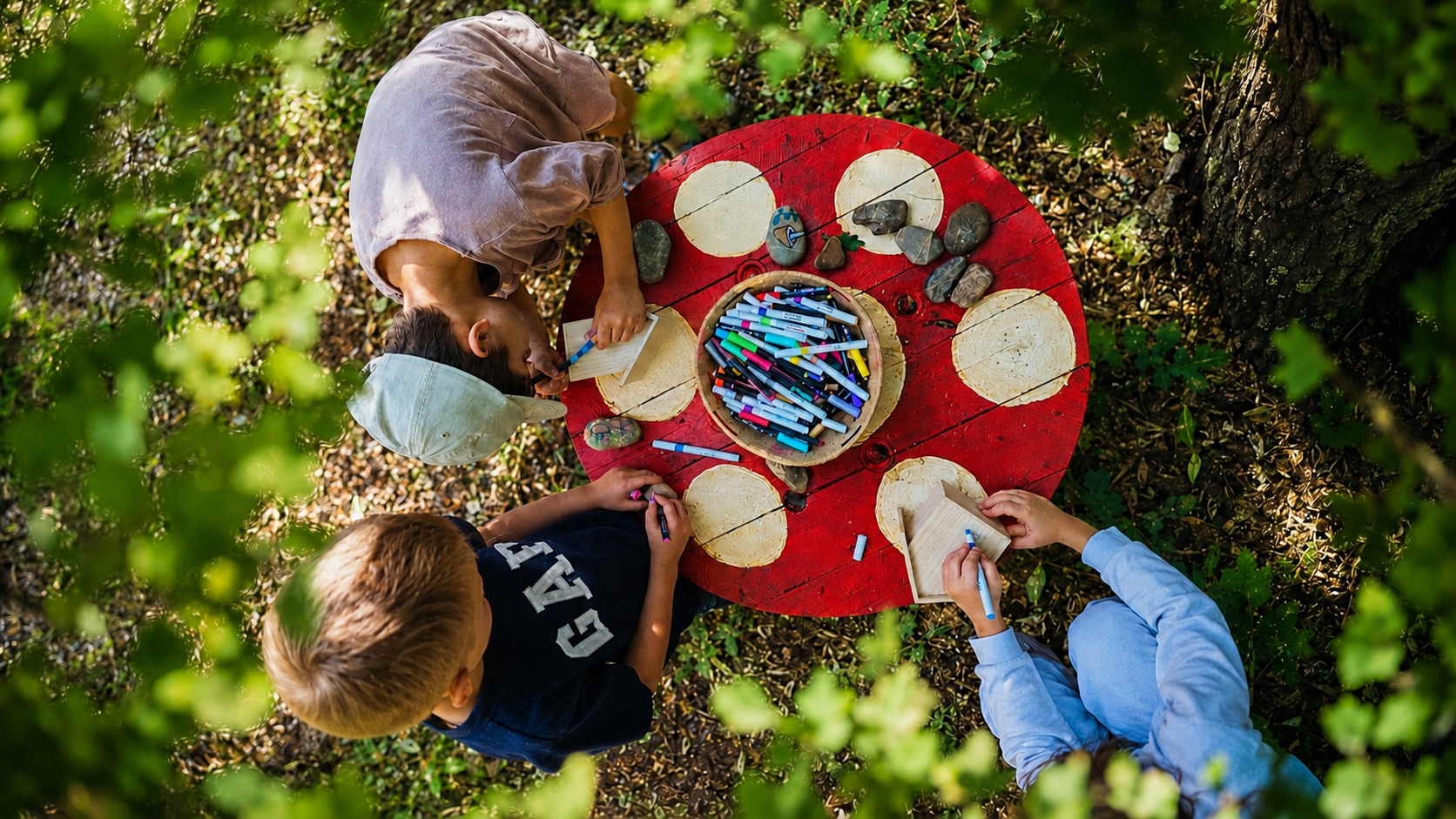 Kinderen die samen buiten aan een tafel iets maken